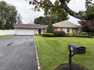 Same tan ranch house, wider angle showing the full lawn and driveway